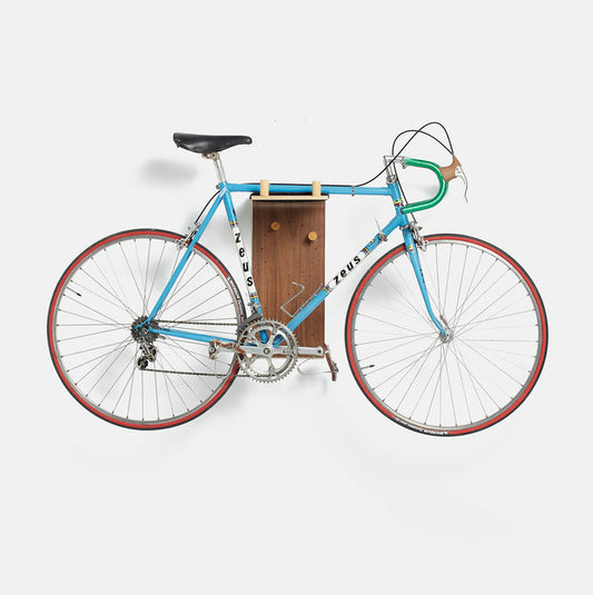 Bicicleta colgada en la estanteria flotante de pared Brera en madera